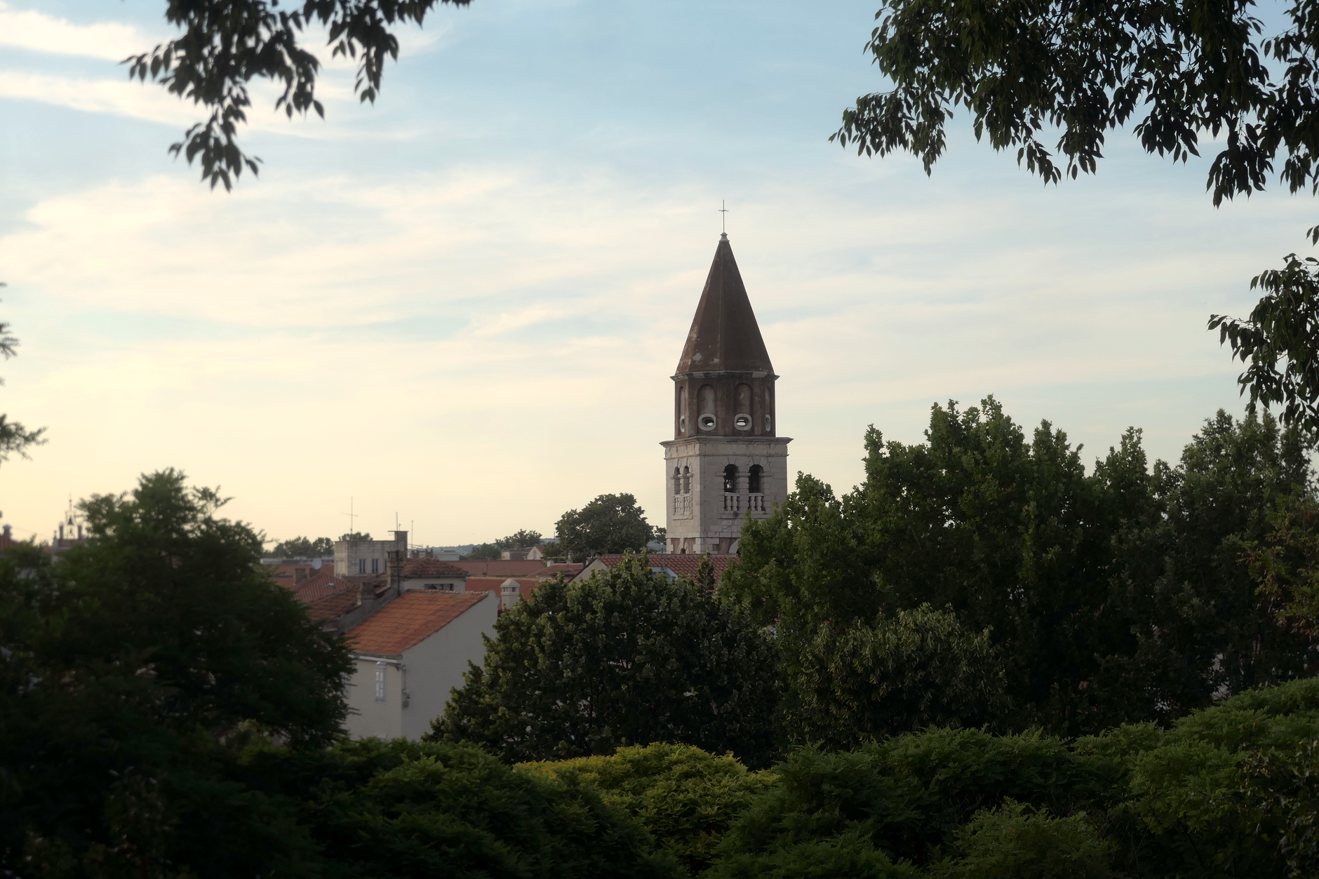 Malerische Ansicht eines historischen Glockenturms inmitten üppigen Grüns in Zadar, Kroatien.
