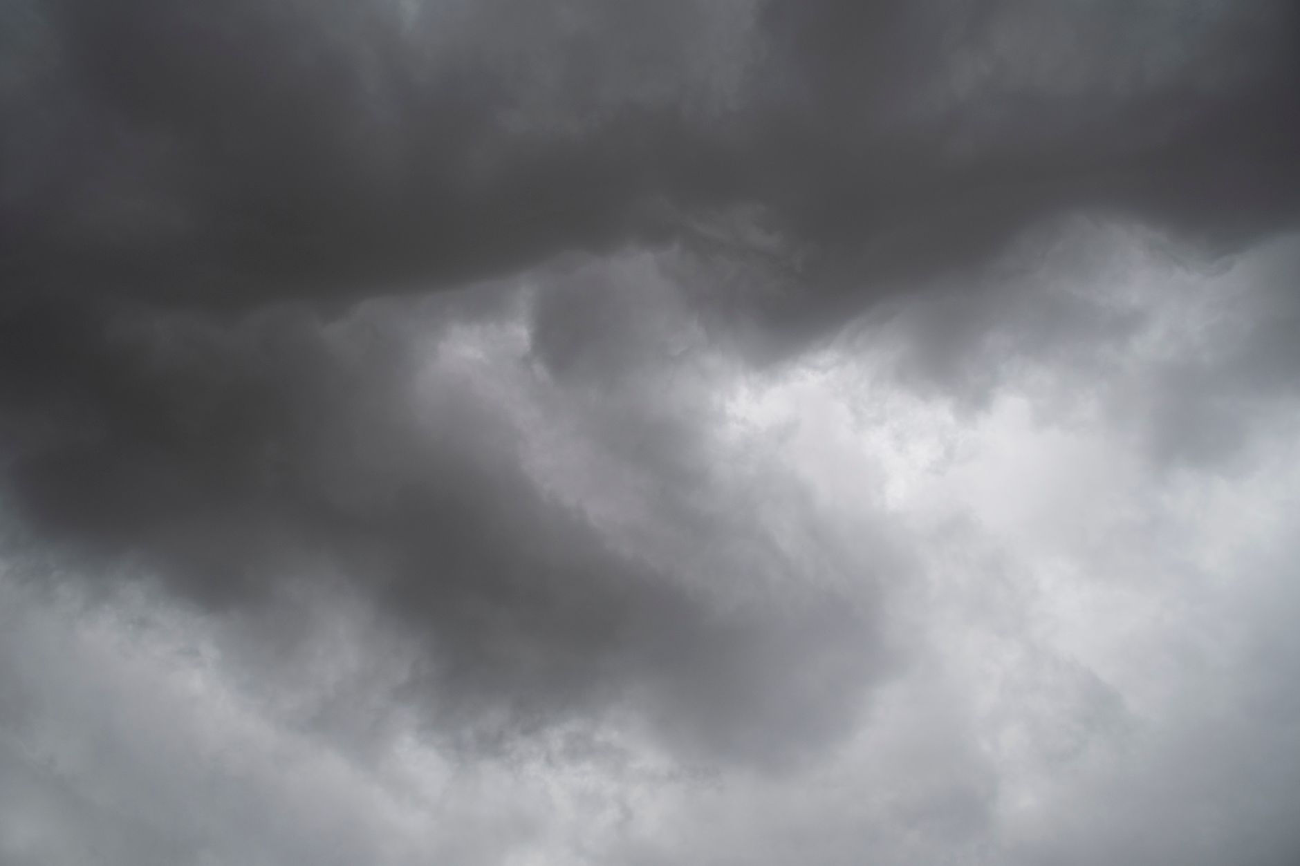 Düsterer, bedeckter Himmel voller dunkler Gewitterwolken, der eine dramatische Wetterszene einfängt.