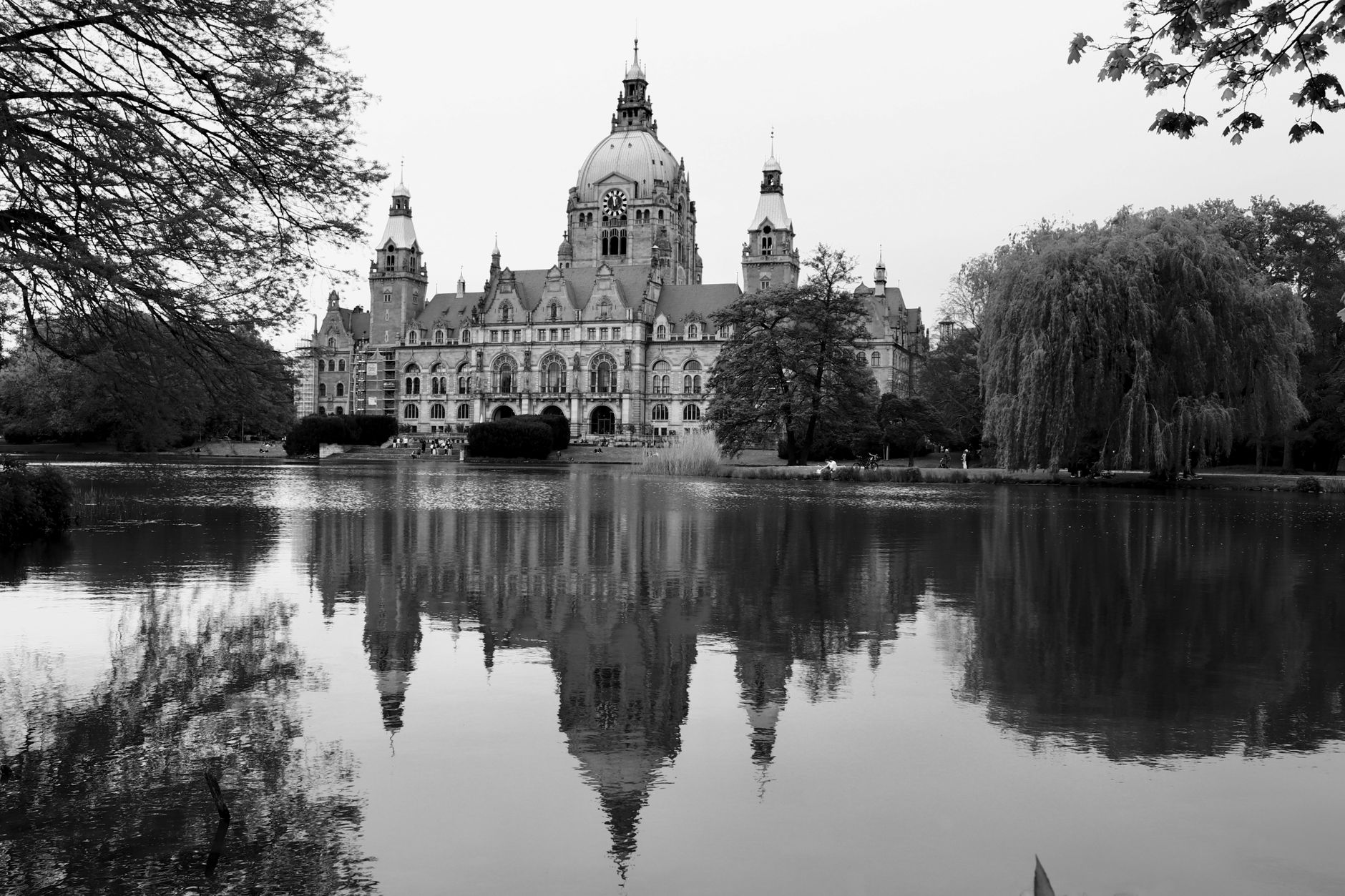 Schwarzweißfoto des Neuen Rathauses in Hannover, im Teich reflektiert.