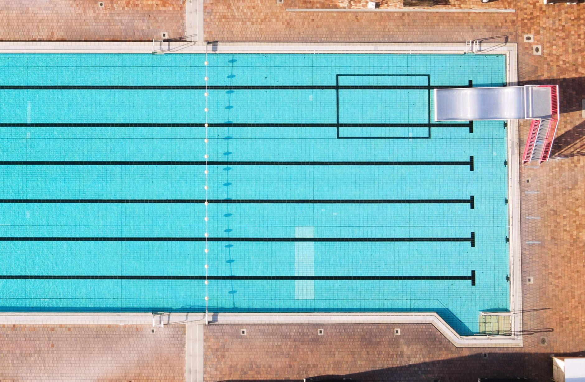 Ansicht von oben auf einen makellosen Swimmingpool mit klarem Wasser und Sprungbrett in Oberviechtach.