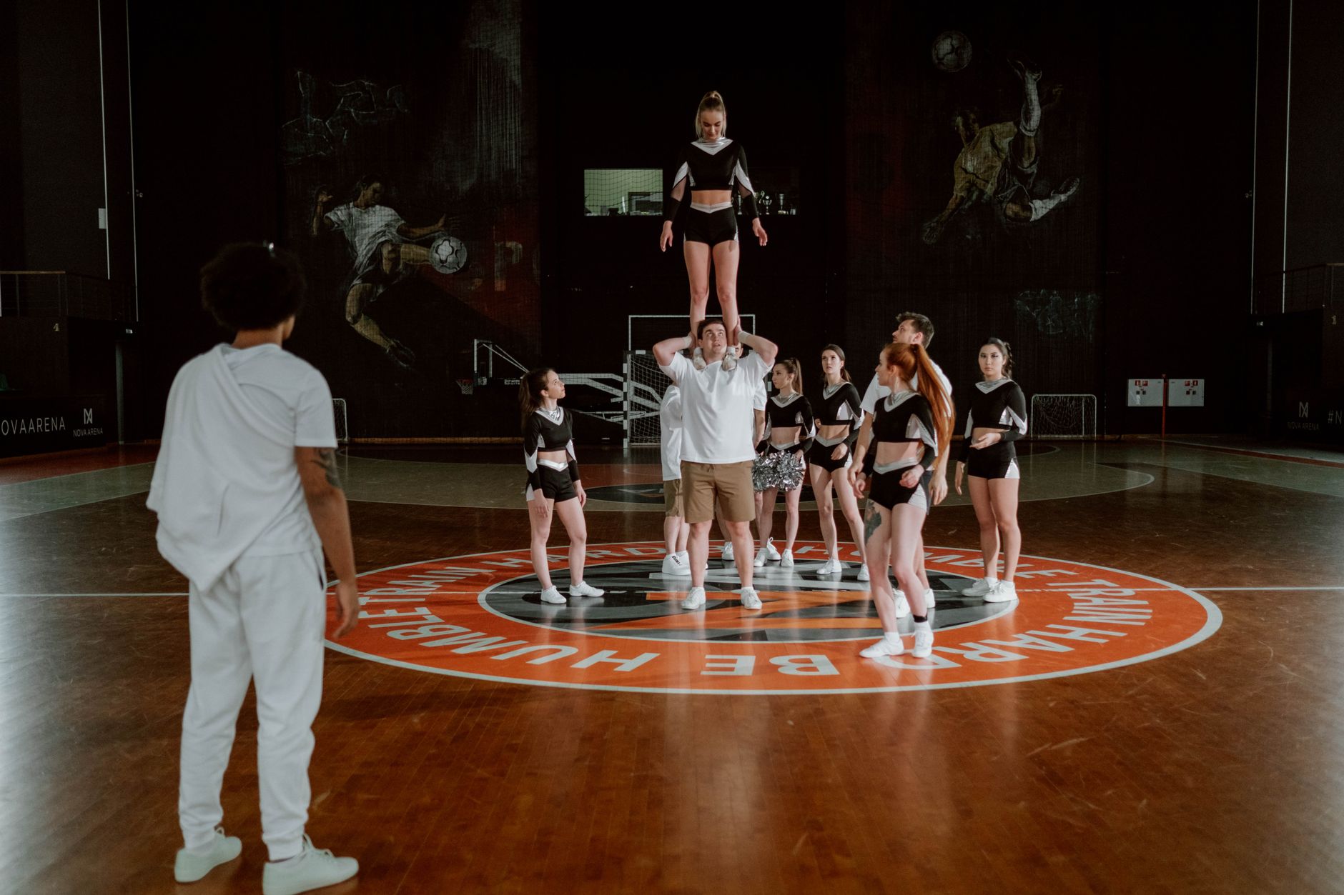 Cheerleading-Team, das in einem stilvollen Innenraum seine Routinen übt und Geschicklichkeit sowie Teamarbeit demonstriert.