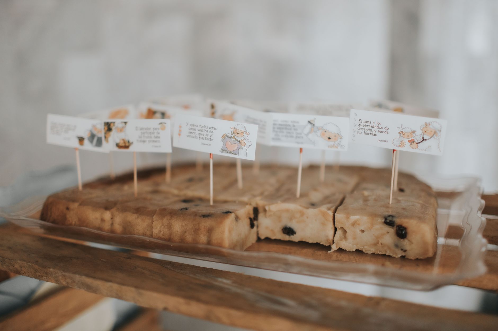 Geschnittener Früchtekuchen mit Rosinen auf klarem Tablett, schön präsentiert mit kleinen Fahnen.