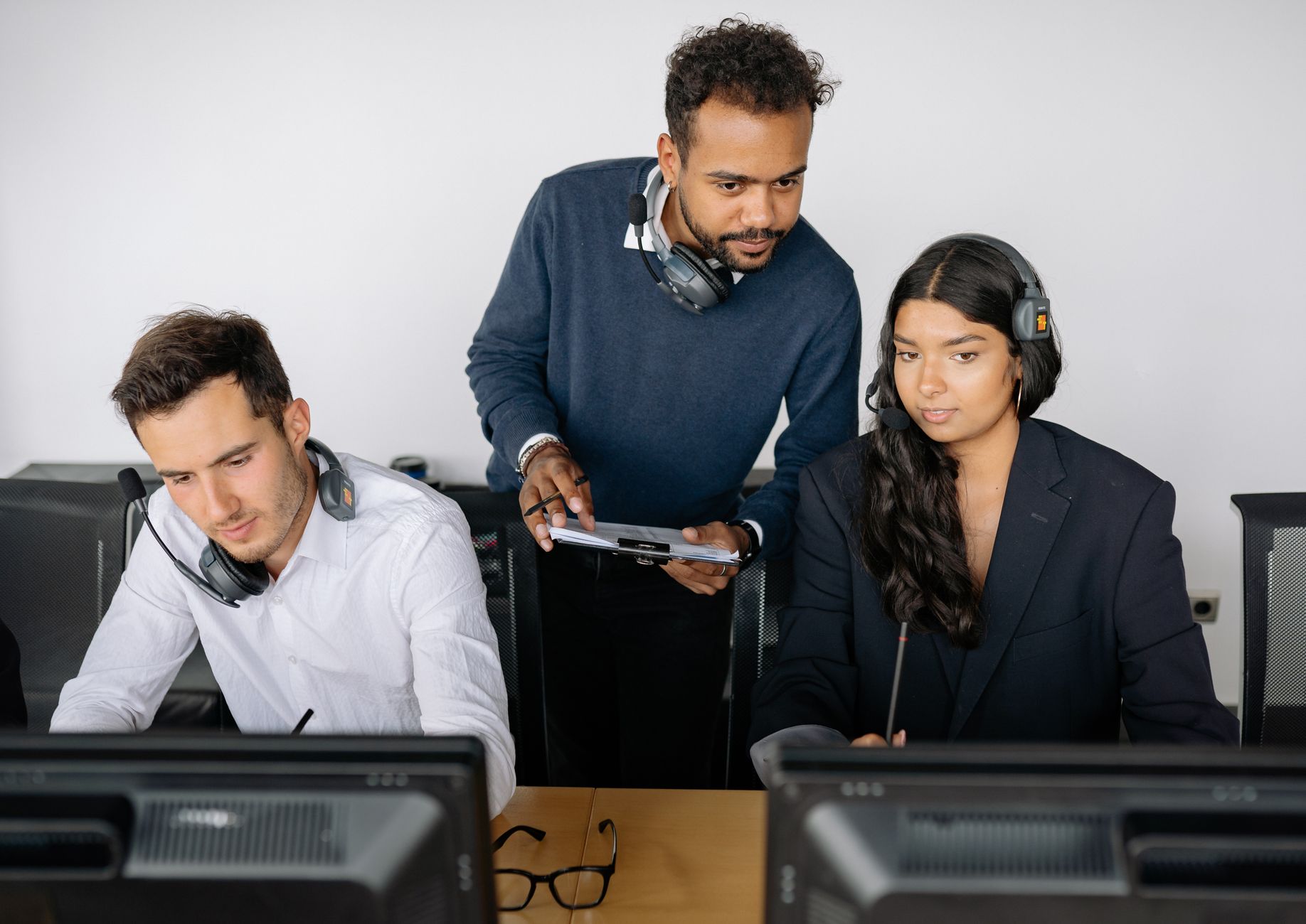 Büro-Team arbeitet mit Headsets an einem Projekt zusammen.