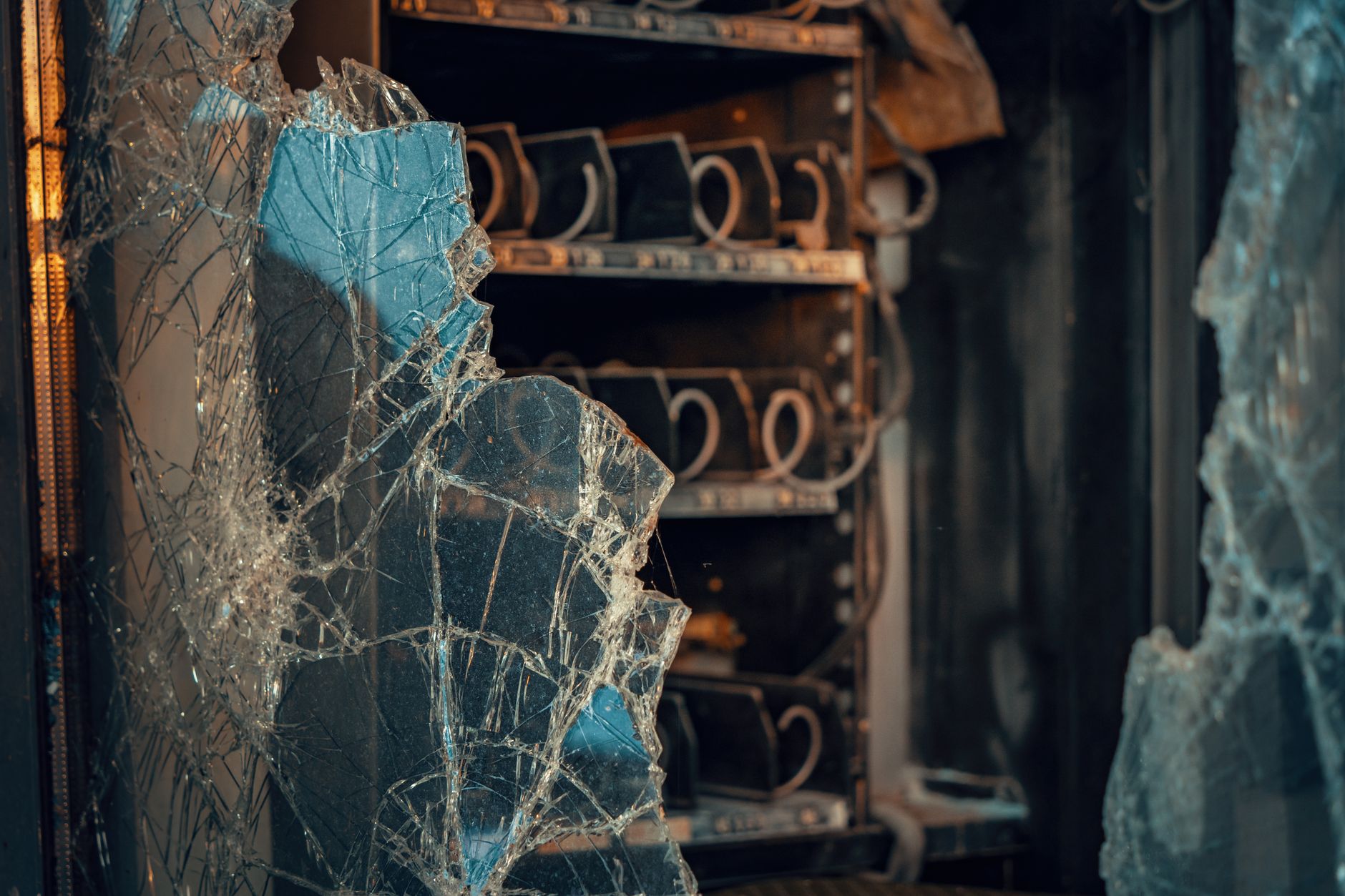 Nahaufnahme von zersplittertem Glas mit industriellen Regalen in einer österreichischen Umgebung.