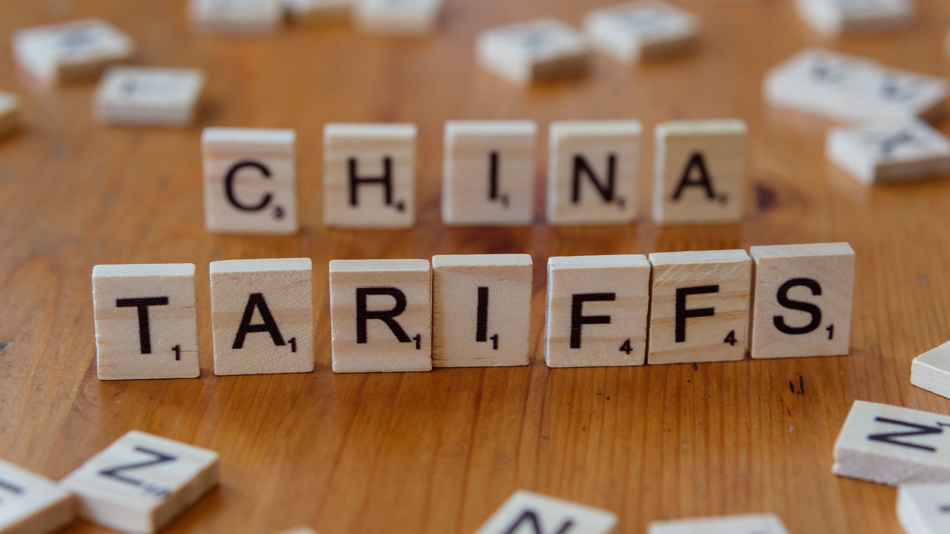 Scrabble-Buchstaben, die 'China' und 'Zölle' buchstabieren, symbolisieren globale Handelsprobleme.
