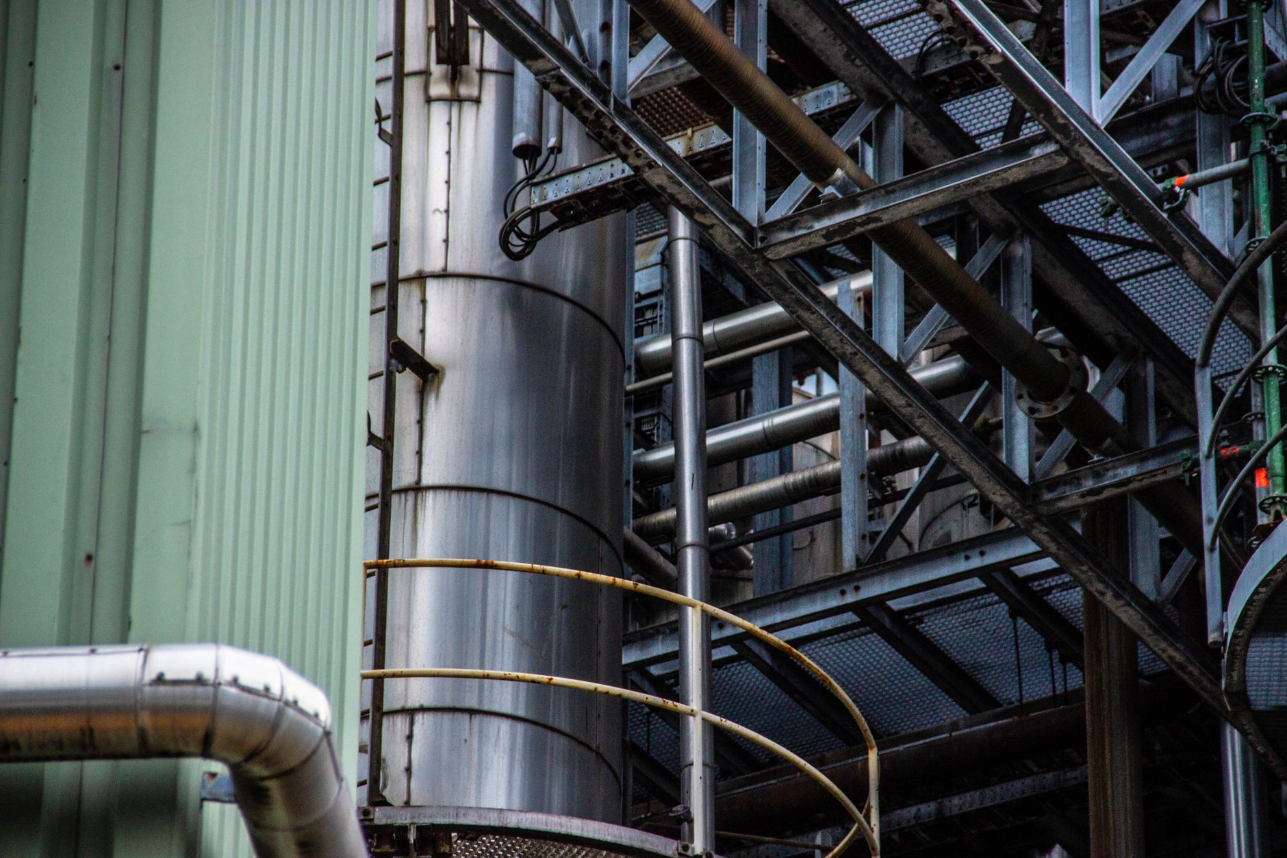 Nahaufnahme einer industriellen Metallstruktur mit Rohren und Stahlrahmen im Freien.