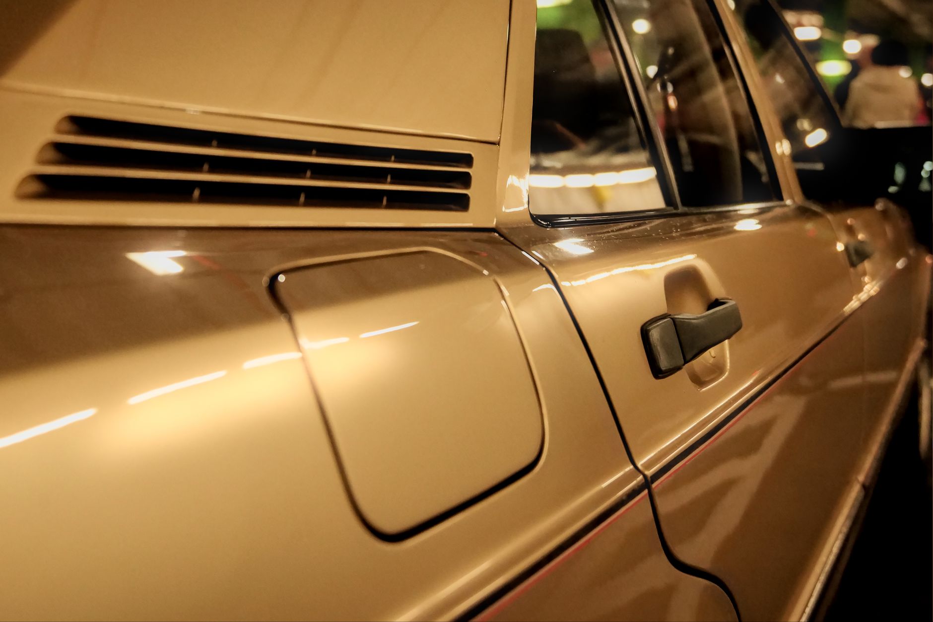 Eine Nahaufnahme eines goldenen Mercedes-Benz im Vintage-Stil, die seine eleganten Linien und sein klassisches Design zur Schau stellt.