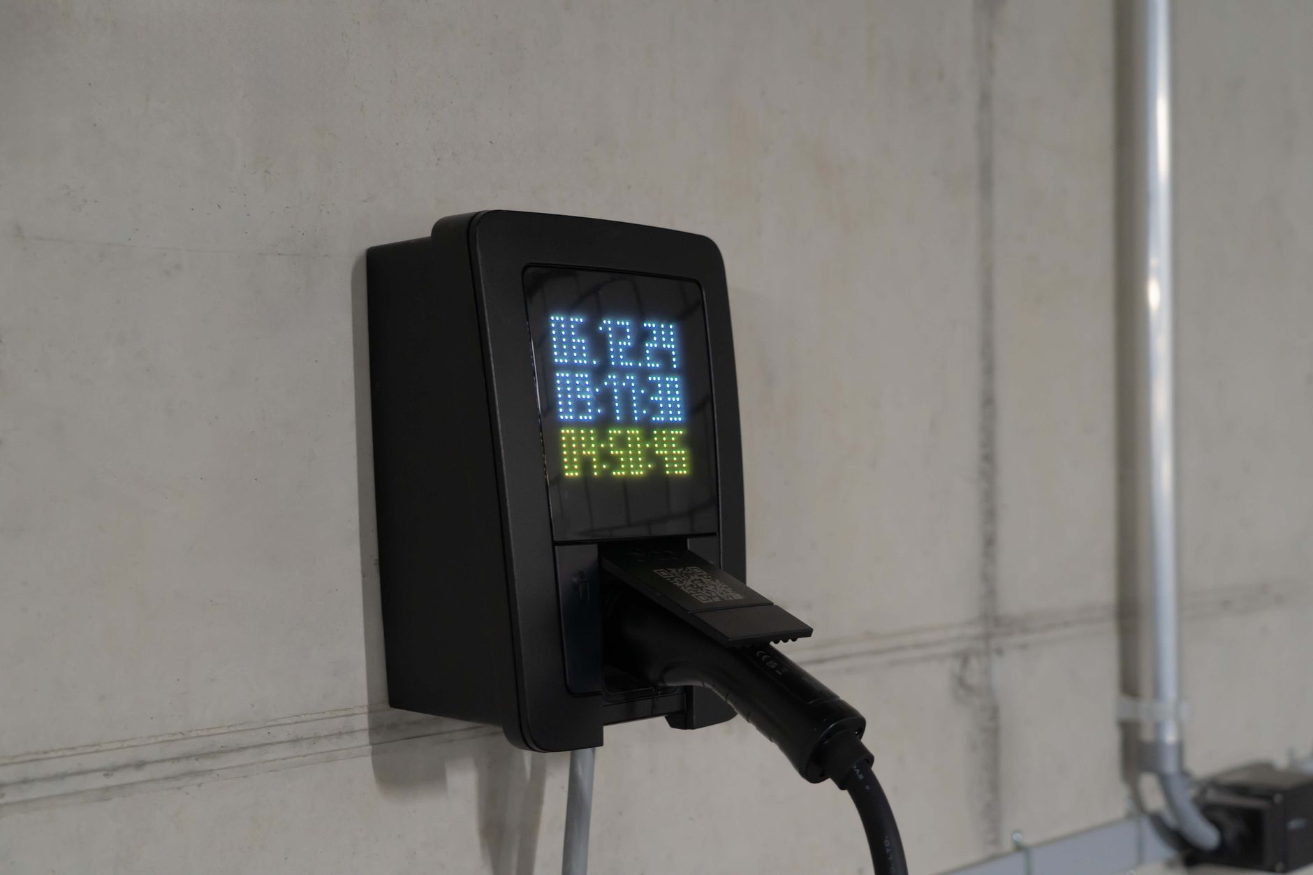Nahaufnahme einer Ladestation für Elektroautos mit digitaler Anzeige, die Ladewerte zeigt.