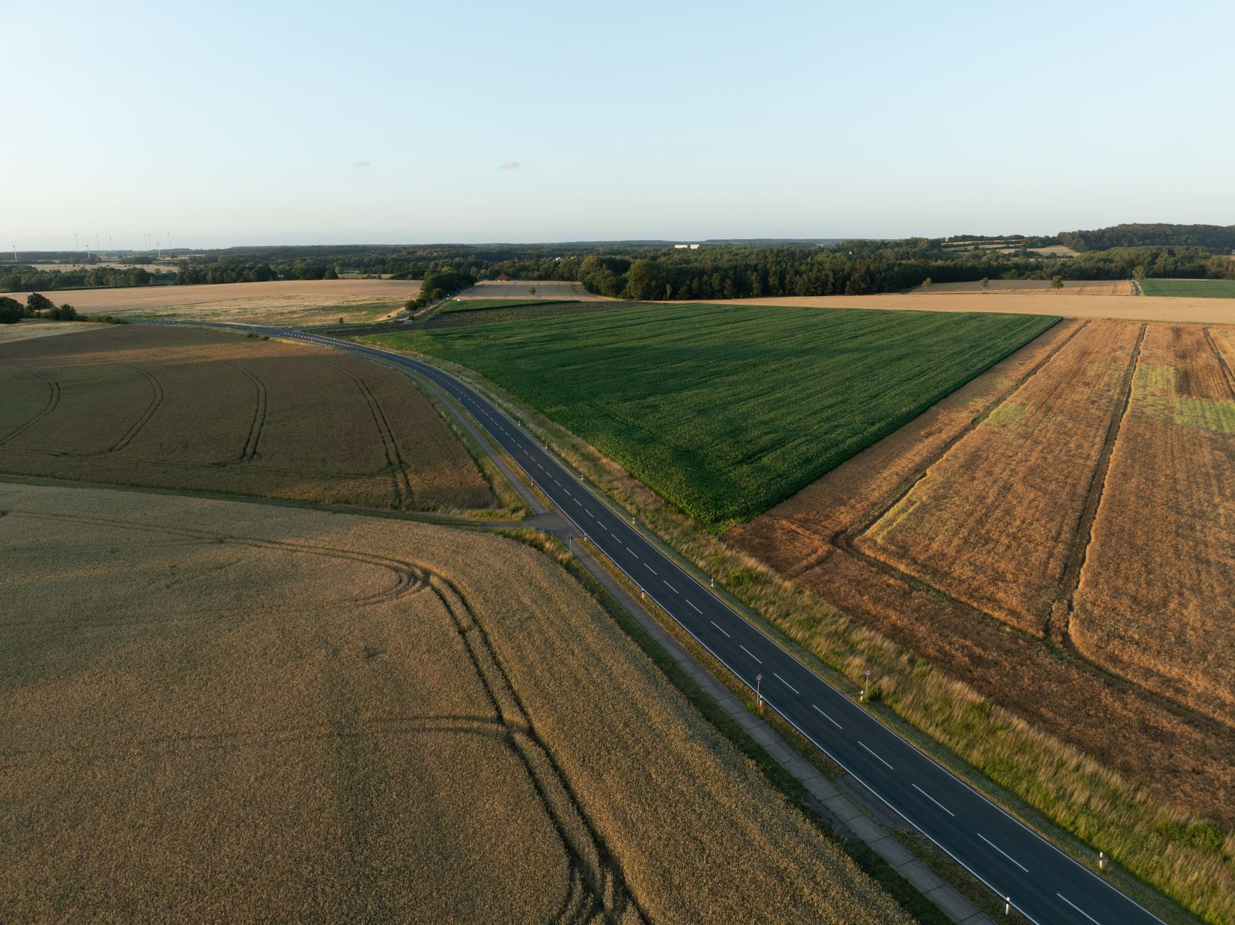 Luftaufnahme einer ländlichen Straße und landwirtschaftlicher Felder in Königslutter, Deutschland im Sommer.