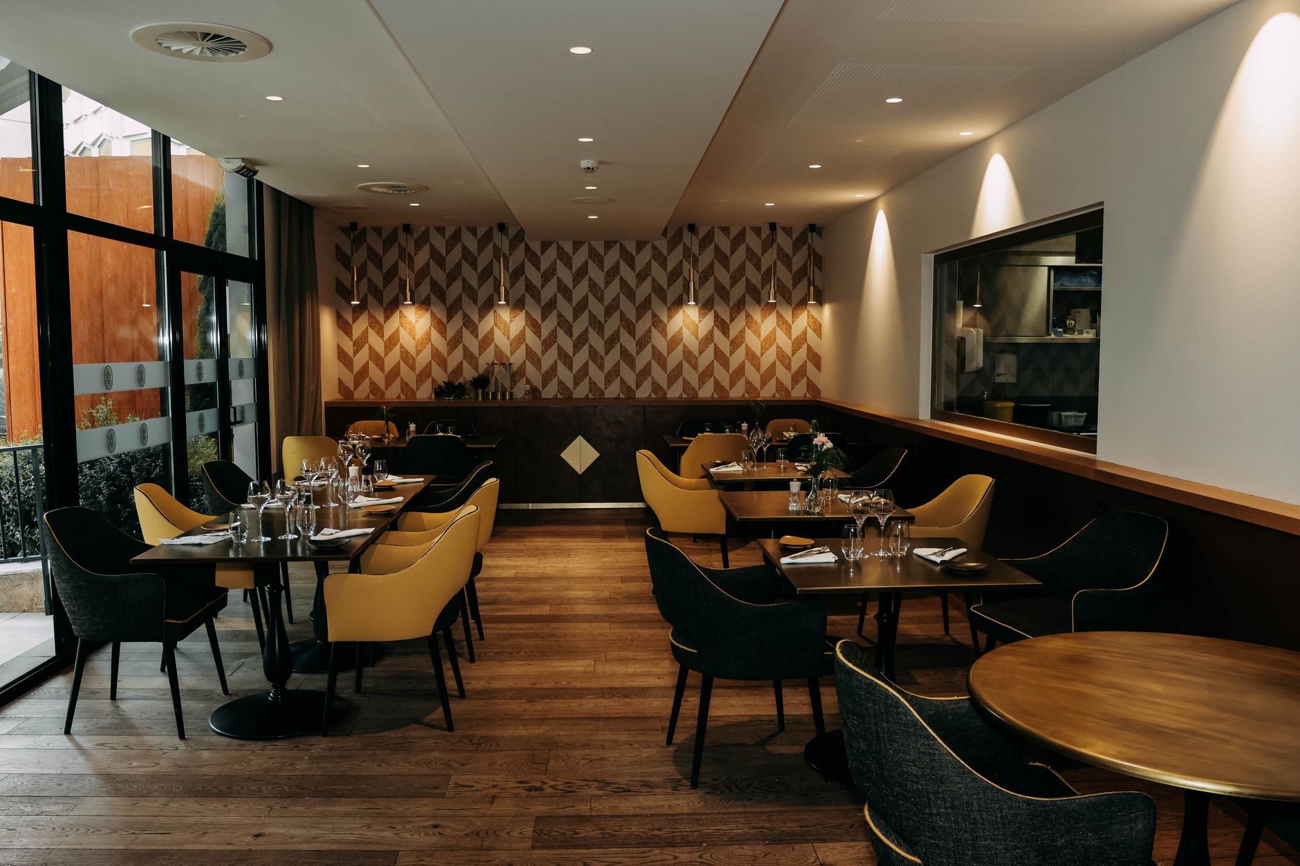 Stilvolles Restaurant-Interieur mit modernem Dekor, eleganten Möbeln und gut gedeckten Esstischen.