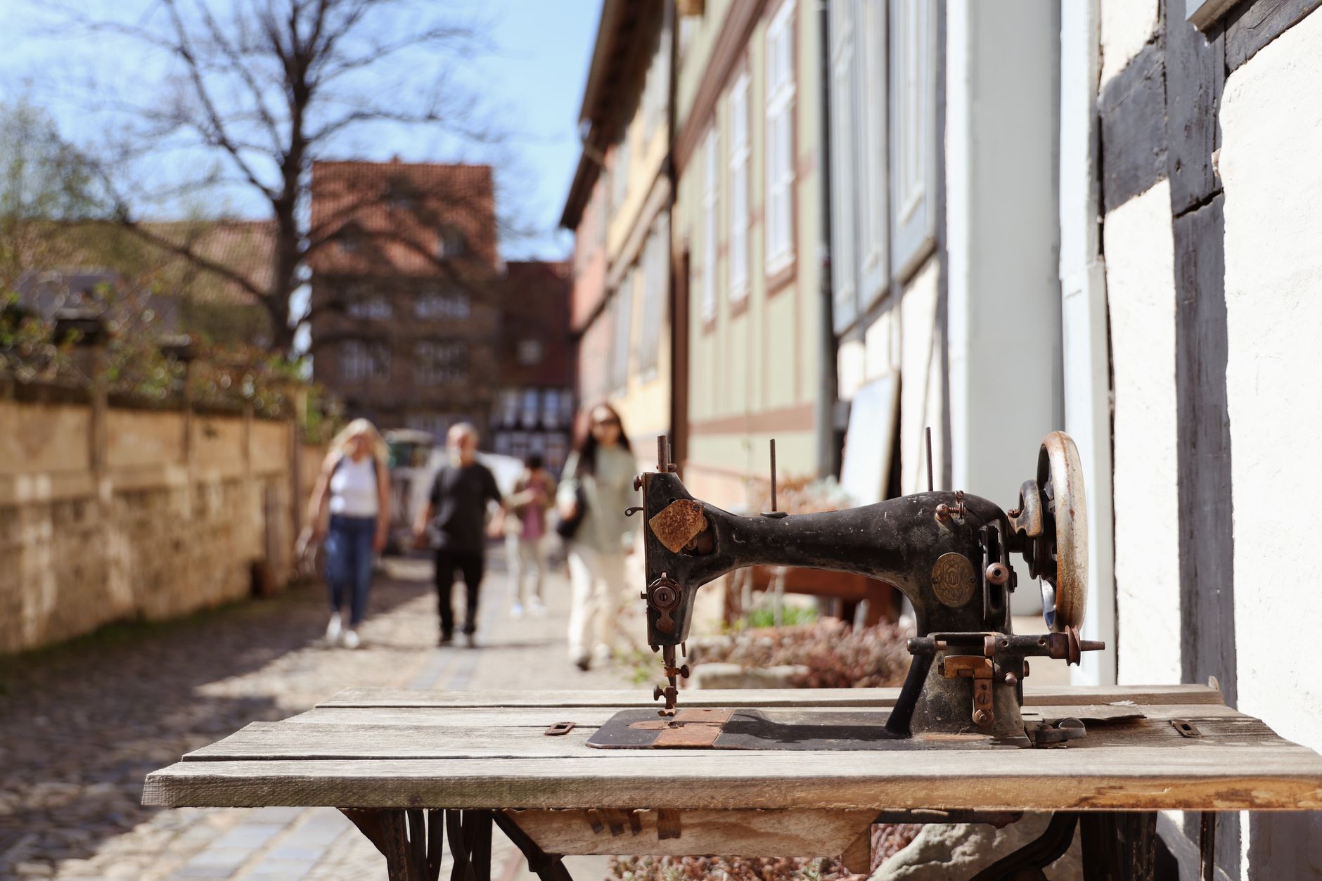 Alte Nähmaschine in einer malerischen Straße in Quedlinburg, Deutschland, die eine Vintage-Atmosphäre einfängt.