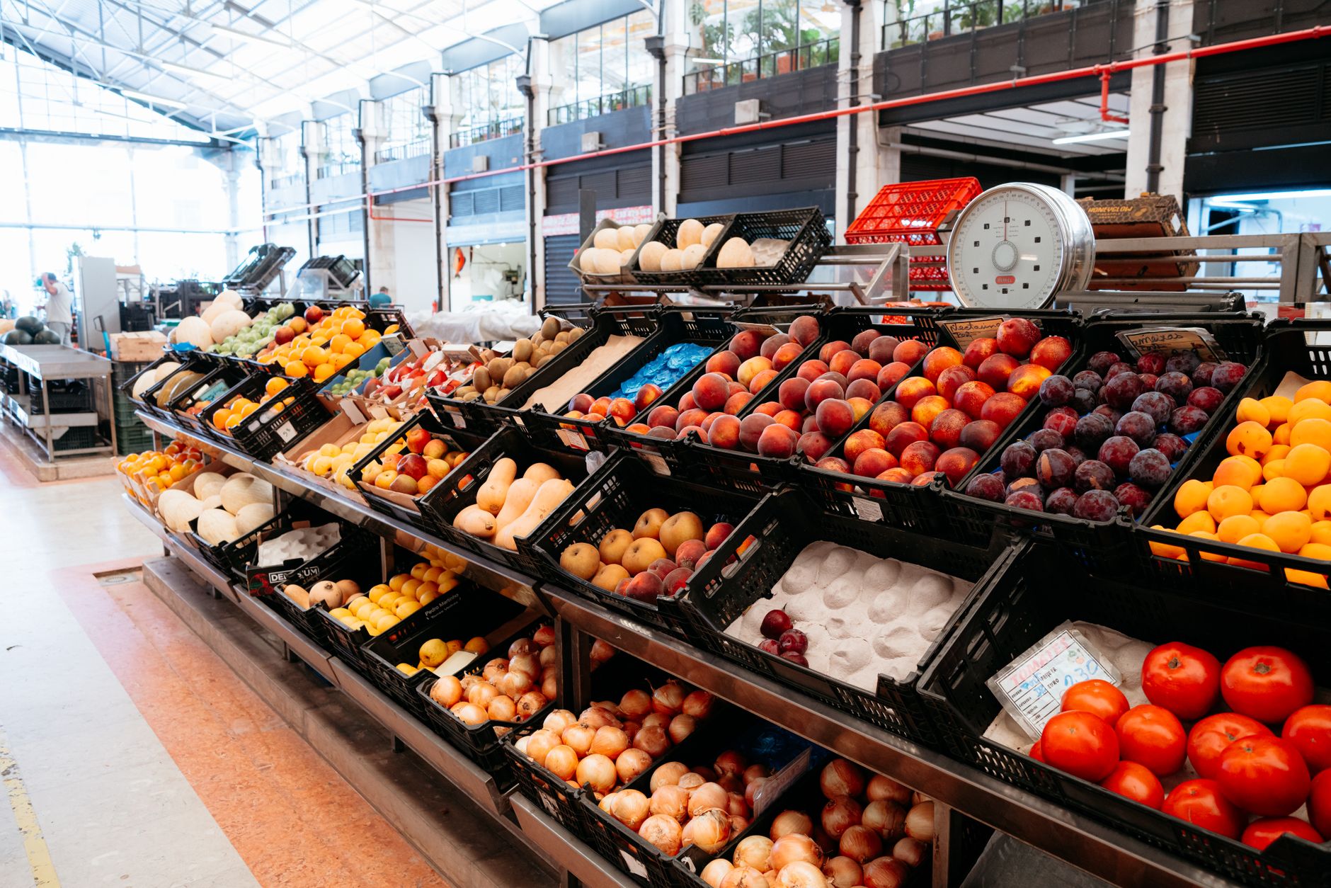 Bunte Vielfalt an Obst an einem Marktstand, die Frische und Fülle in Innenräumen zeigt.