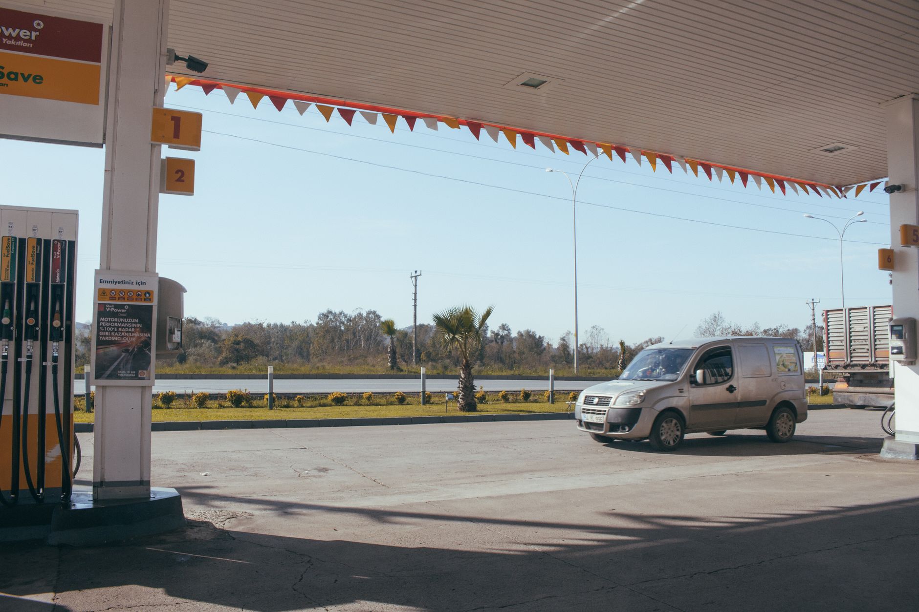 Ein Van, der an einer Tankstelle am Straßenrand unter einem klaren blauen Himmel geparkt ist.