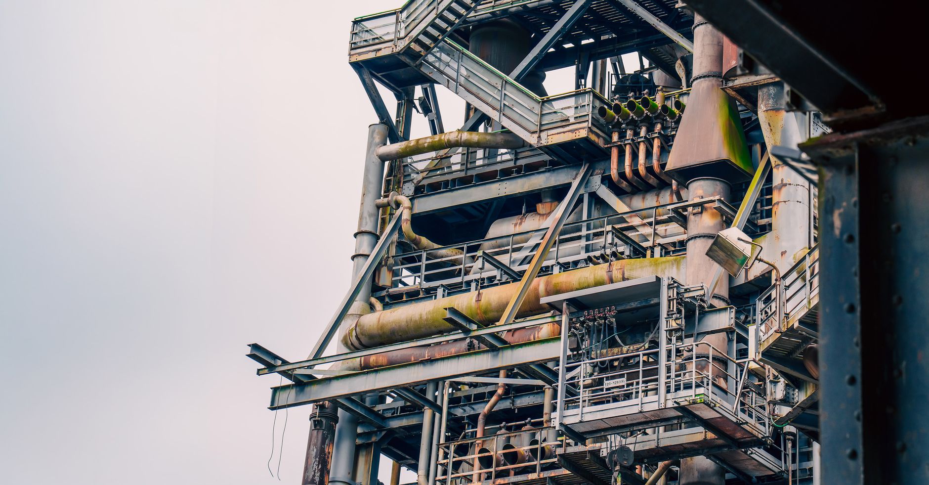 Ein eindrucksvoller Blick auf eine verrostete Industrieanlage mit alternden Maschinen und Bauwerken.