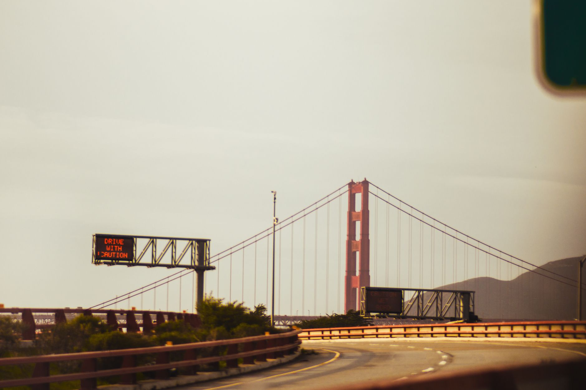 Golden Gate Bridge und „Vorsicht beim Fahren“-Schild an einem klaren Tag in San Francisco.