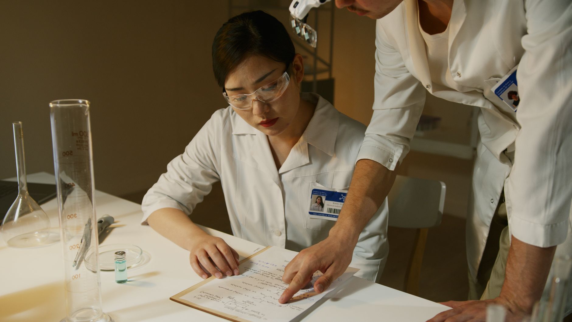 Forscher in Laborkitteln, die experimentelle Notizen während einer wissenschaftlichen Studie analysieren.