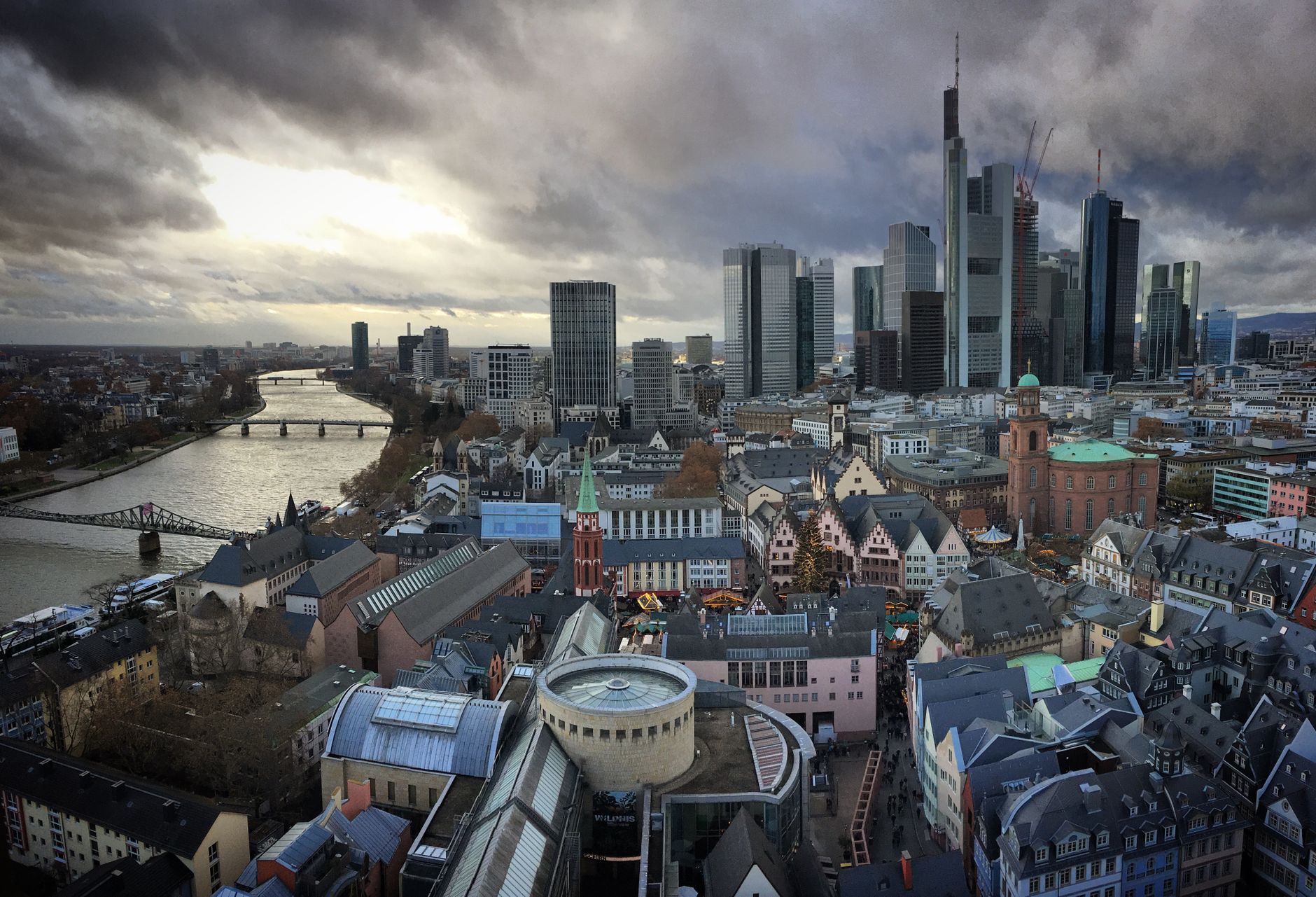 Luftaufnahme der modernen Skyline von Frankfurt und des historischen Zentrums entlang des Main bei Dämmerung.